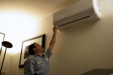 hassler employer pointing to a wall heat pump unit