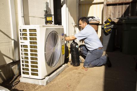 hassler employee working on a heat pump