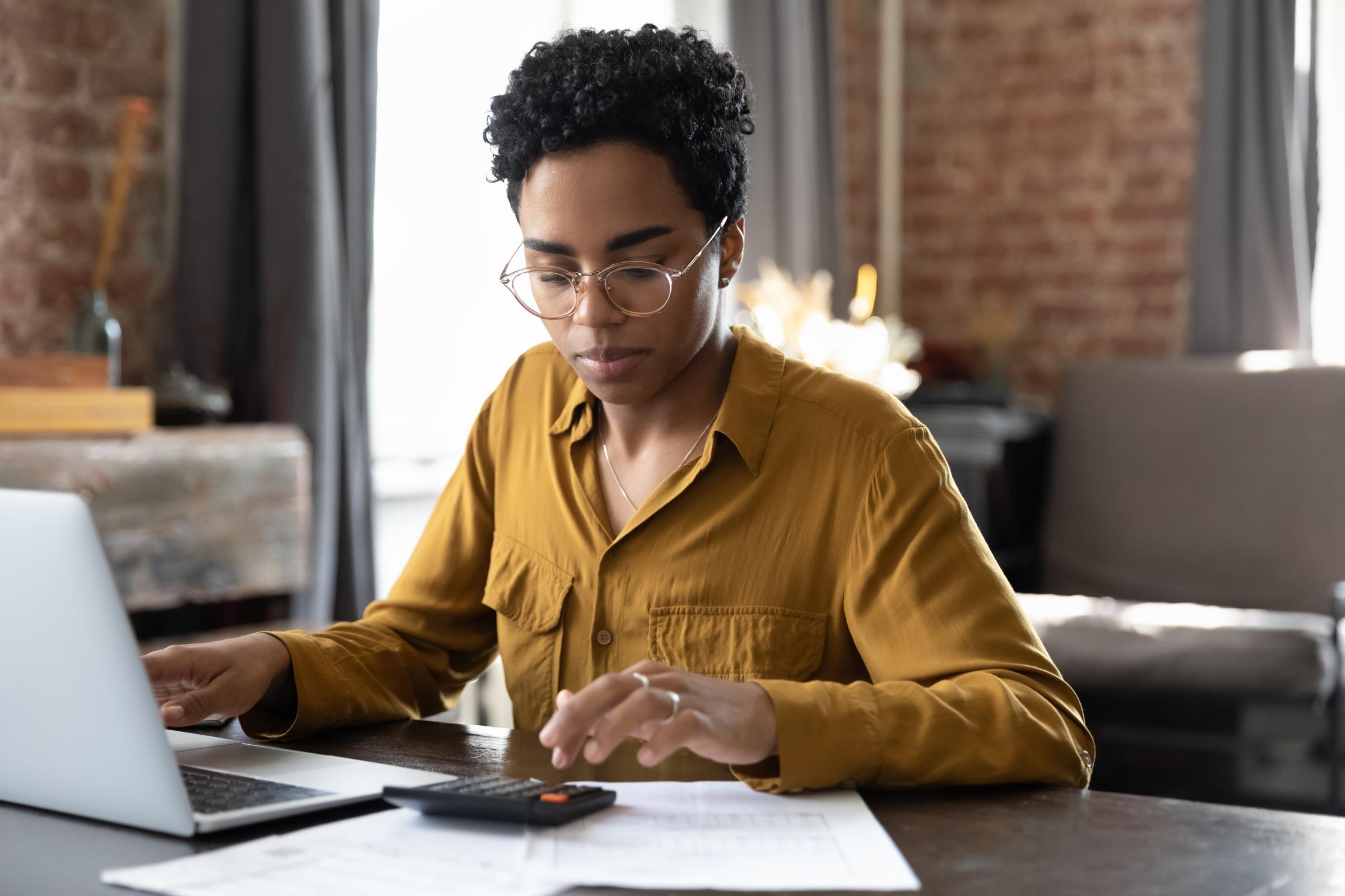 woman using a calculator to pay her bills